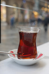 Turkish tea served in a traditional glass cup on a busy street
