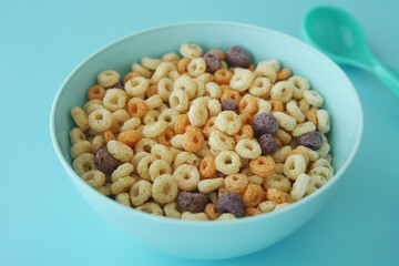 Colorful cereal in a bowl on a light blue surface