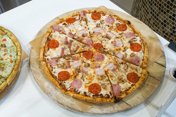 Pizza is a traditional Italian dish in the form of a round yeast cake baked with a filling laid on top.