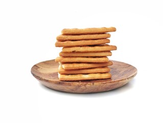 Pile of square cracker biscuit on plate isolated on white background 