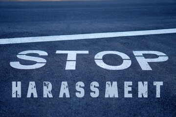 stop harassment concept.words written next to a stop sign on the asphalt of the road.