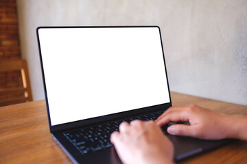 Mockup image of a woman using and typing on computer laptop with blank desktop screen