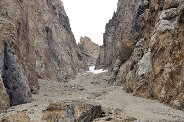 A ravine or valley formed between two large rocks in the Gray Mountains is covered with snow. The snowy valley between the mountains is used as a road