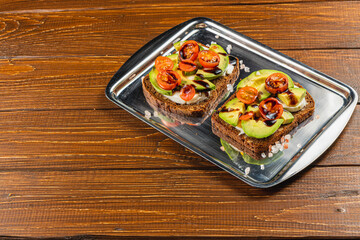 Freshly prepared open-faced sandwiches with vegetables on a wooden table