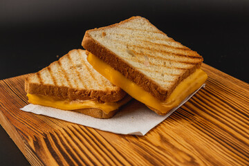 Grilled cheese sandwich served on wooden board for breakfast or snack