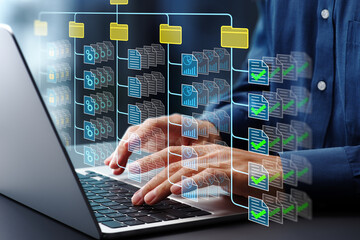 Document management system DMS. Folder structure and classification system. File and folder icons. Businessman using laptop computer for controlling document versions.