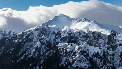Obraz premium Landscape of snowy mountains covered by clouds 