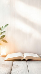 Open book on wooden table with warm light and plant nearby