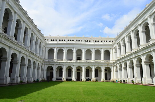 Chiostro interno del Indian Museum di Calcutta in una calda giornata estiva soleggiata. Vista prospettica architettonica di un chiostro in stile europeo a due ordini di colore chiaro in pietra e marmo