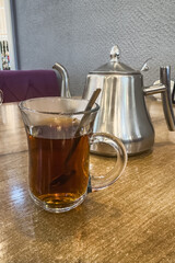 Traditional Turkish tea cup armudu with black aromatic tea and a teaspoon. Selective focus.