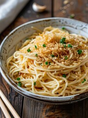 Delicious plate of spaghetti topped with crispy garlic and fresh green onions served in a rustic bowl