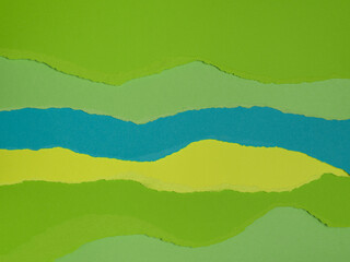 Obraz premium Strips of torn paper of different shades of green, blue and yellow arranged one on top of the other