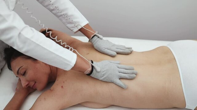 Micro sensory electrical BIO EMS micro-current treatment for face and body electrode stimulation with conductive gloves. Anti wrinkle and anti-aging lifting. Selective focus.