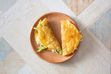 A top down view of some fried tacos, on a plate.