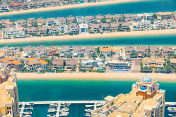 Aerial view of luxury villas on The Palm Jumeirah artificial island with sandy beach and turquoise waters of Arabian Gulf n Dubai city, United Arab Emirates
