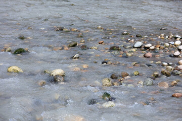 Shallow River Water Flowing Rapidly Over Colorful Wet Stones And Pebbles. Natural Abstract Background Of Mountain Stream Bed. Close Up.