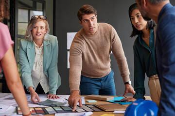 Group of designers and interior architects reviewing plans