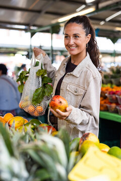 Woman shopping for fresh produce at a local market outdoors