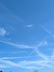 Blue Skies with wispy chemtrail aeroplane lines and fluffy white clouds