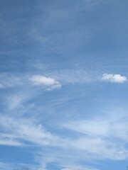 Blue Skies with wispy chemtrail aeroplane lines and fluffy white clouds