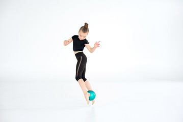 girl, rhythmic gymnast performing with ball, showing skills and stay isolated on white background. Concept of sport, active lifestyle, hobby.