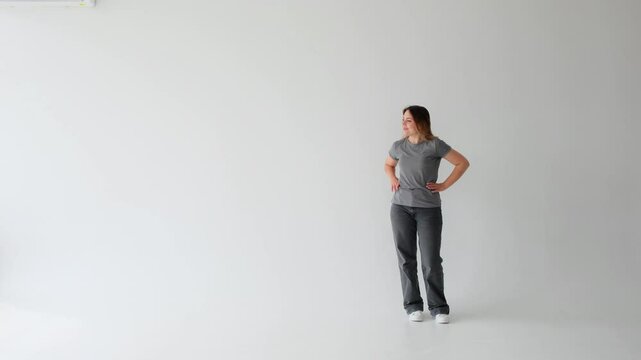 Positive Caucasian young adult woman looking left to copy space on white background. Concept of a confident, delighted, smiling lady