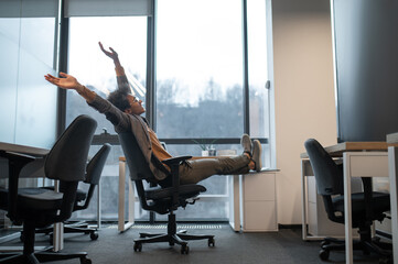 Man wearing suit sitting in office with big window