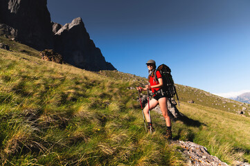 Fototapeta premium Girl Traveler hiking with backpack at rocky mountains landscape Travel Lifestyle concept adventure summer vacations outdoor