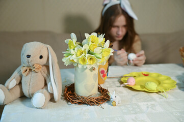 
girl paints easter eggs for the holiday at home