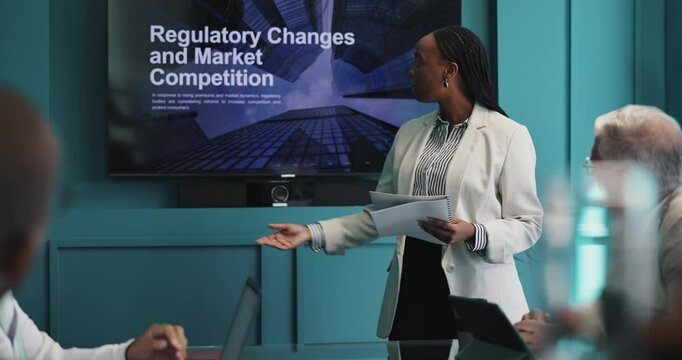 Presentation, meeting and businesswoman in office with team for regulatory changes and market competition. Discussion, screen and speaker with bankers for financial capital requirement for company.