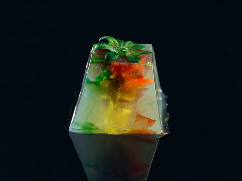 Close-up overhead view of a strawberry and LED lights in a box of gelatin