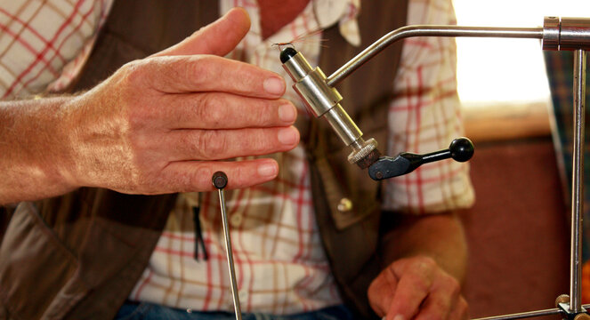 Close-up of a Man using a machine to make his own fishing flies