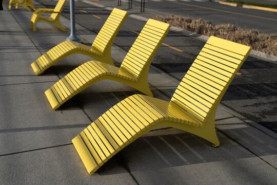 Close-up of a row of yellow Chairs on a sidewalk, Victoria, British Columbia, Canada