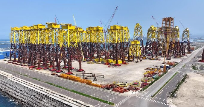 Aerial view of New Taipei City harbor with offshore wind turbines transition platforms. Prepare for offshore deployment. Sunny day with blue sky in Taiwan. Offshore wind farm in Asia.