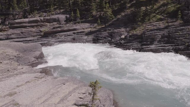 Raging river flowing through rocky terrain in Mistaya and Sunwapta, Canada
