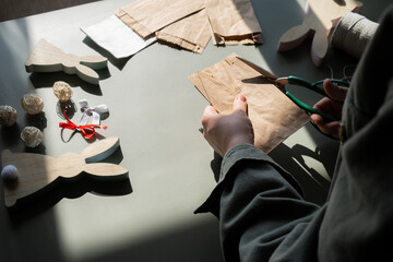 DIY process of woman making candid Easter present paper bag bunny arrangement decor. Series of...