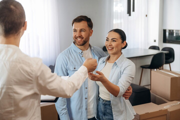 Obraz premium Receiving keys. Couple are buying new house with the help of manager