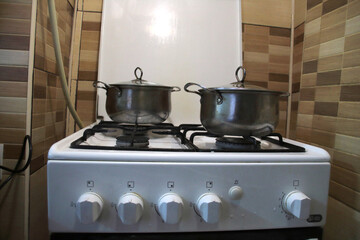 Cooking on a gas stove. Two stainless steel pots are placed on the surface.