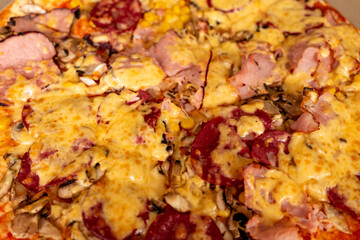 Freshly baked pizza topped with various meats and mushrooms