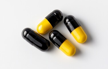 Four Capsules Lying on White Background in Black and Yellow Color