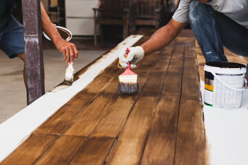 Two house painter painting a floor outside the house.