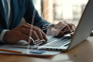 Close-up of Hands Typing on Laptop with Electric Vehicle Concept Overlaid on Office Desk with Documents and Modern Background