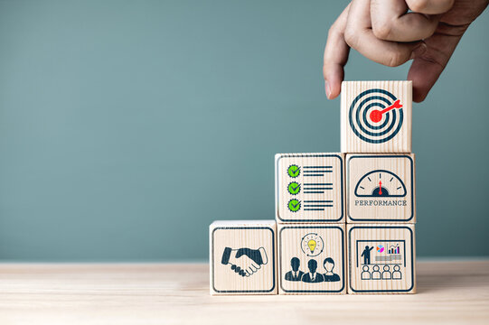 Concepts and methods for developing organizations towards success. Business icons on wooden blocks represent establishing Strategy and Implementing plan. with copy space