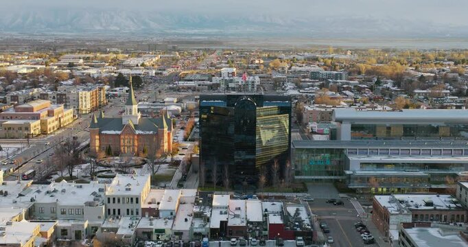 Sunset glow over buildings in Provo, Utah during the winter - drone shot