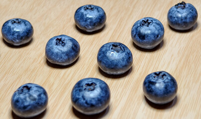 Stack of blueberries and shadow. Fresh colorful fruits with copy space and Background is wooden floor.