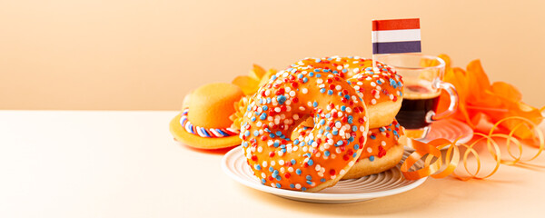 Banner with Glazed orange donuts with Dutch event Kings day in background. National holiday Koningsdag on 27 April in the Netherlands. Holland culture concept with copy space