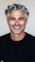 Obraz premium Handsome Mature Man with Graying Wavy Hair Smiling