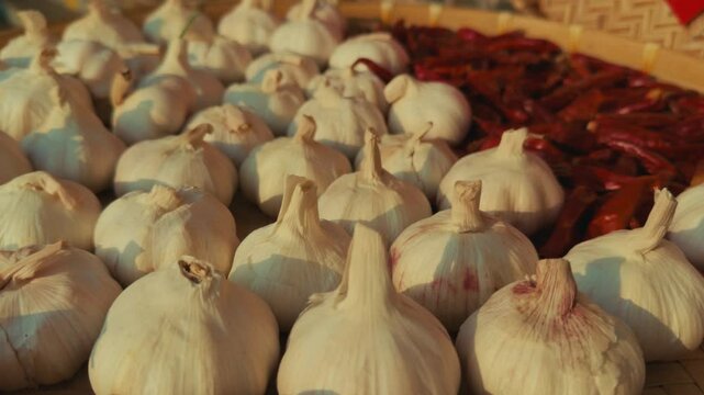 Fresh garlic bulbs and dried chili peppers on a market table in Wuzhen, China