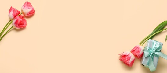 Fototapeta premium Beautiful tulips and gift on beige background with space for text, top view