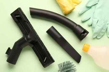 Vacuum cleaner attachments with supplies on green background